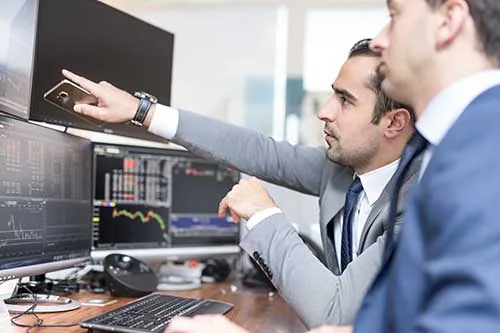 Technicien I2C et responsable informatique devant un écran de supervision